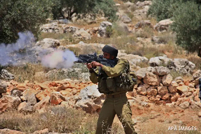 An Israeli soldier fires tear gas canisters during clashes with Palestinian protestors following a demonstration against Israeli settlements in the West Bank village of Dair al-Hatab, east of Nablus, on June 5, 2011 as I...