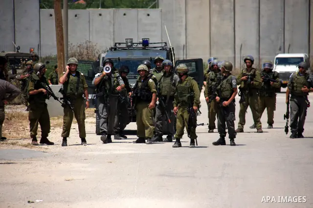 Israeli soldiers fire tear gas canisters during clashes with Palestinians following a protest against Israel's separation barrier in the village Nazlet Issa north Tulkarm in the West Bank on June 7, 2011. Photo by Wagdi...