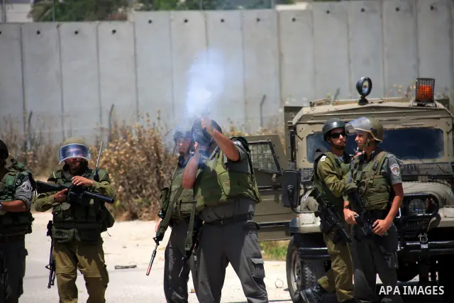 Israeli soldiers fire tear gas canisters during clashes with Palestinians following a protest against Israel's separation barrier in the village Nazlet Issa north Tulkarm in the West Bank on June 7, 2011. Photo by Wagdi...