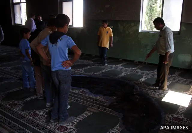 A Palestinian man inspects a partially burn mosque in the West Bank of al-Mughayyir village, some 20 kilometres (12 miles) northeast of Ramallah City on June 7, 2011. Palestinian security sources said Jewish settlers are...