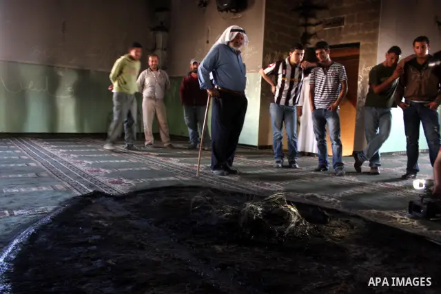 A Palestinian man inspects a partially burn mosque in the West Bank of al-Mughayyir village, some 20 kilometres (12 miles) northeast of Ramallah City on June 7, 2011. Palestinian security sources said Jewish settlers are...