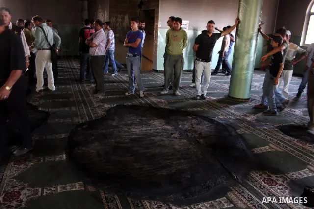A Palestinian man inspects a partially burn mosque in the West Bank of al-Mughayyir village, some 20 kilometres (12 miles) northeast of Ramallah City on June 7, 2011. Palestinian security sources said Jewish settlers are...