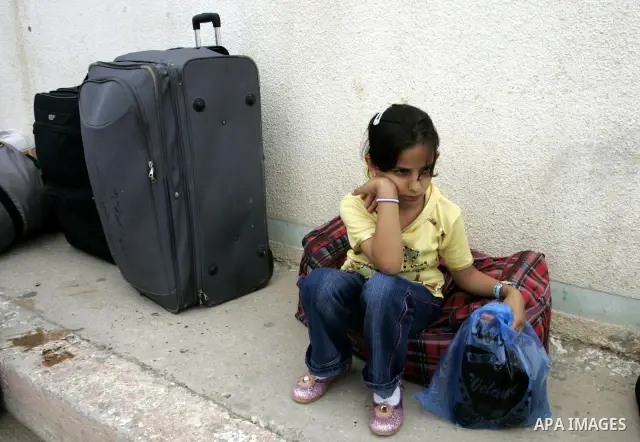 A Palestinian girl waits to cross with her family into Egypt through the Rafah border crossing in the southern Gaza Strip on June 8, 2011 after it was reopened, ending a four-day closure amid disagreements between Egypti...
