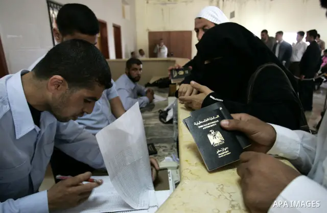 Palestinians border police check documents of travellers waiting to cross into Egypt through the Rafah border crossing in the southern Gaza Strip on June 8, 2011 after it was reopened, ending a four-day closure amid disa...