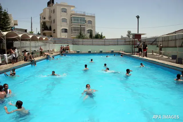 Palestinian boys and girls enjoy swimming in the swimming pool to feel relaxation after completion of their school examinations and the end of schools year, in the West Bank city of Hebron on June 08,2011.Photo by Najeh...
