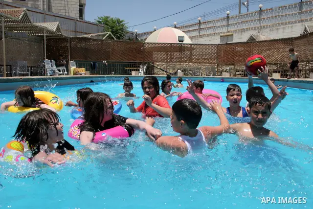 Palestinian boys and girls enjoy swimming in the swimming pool to feel relaxation after completion of their school examinations and the end of schools year, in the West Bank city of Hebron on June 08,2011. Photo by Najeh...