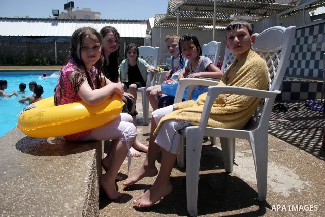 Palestinian girls and boys enjoy swimming in the swimming pool to feel relaxation after completion of their school examinations and the end of schools year, in the West Bank city of Hebron on June 08,2011. Photo by Najeh...