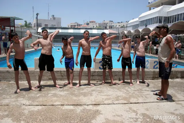 Palestinian girls and boys enjoy swimming in the swimming pool to feel relaxation after completion of their school examinations and the end of schools year, in the West Bank city of Hebron on June 08,2011. Photo by Najeh...