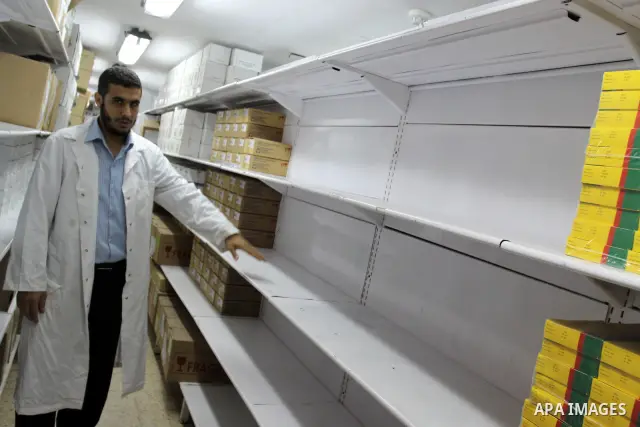 A Palestinian pharmacist stands next shelves which empty from medicines at Al-Shefa Hospital in Gaza City on June 8,2011 as Gaza Strip faces a lack of medicines. Photo by Mohammed Asad