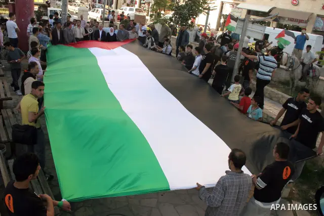 Palestinians hold up Palestinian National flag during a protest to mark the 44th anniversary of 'Naksa,' Arabic for setback, in the West Bank city of Hebron on June 09, 2011, as Palestinian activists in Jerusalem, the We...