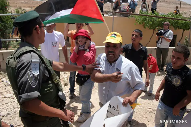 Israeli forces disperse a demonstration by Palestinian and foreign peace activists against Israeli settlements in the West Bank village of Al-Tuwani, near Hebron, on June 10,2011. Photo by Najeh Hashlamoun .