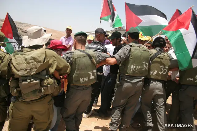 Israeli forces disperse a demonstration by Palestinian and foreign peace activists against Israeli settlements in the West Bank village of Al-Tuwani, near Hebron, on June 10,2011. Photo by Najeh Hashlamoun .