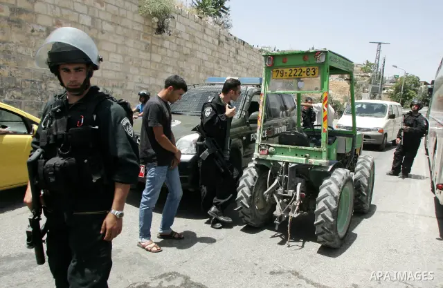 Israeli soldiers stand guard as Palestinian Muslim worshippers attend Friday prayers near a protest tent in the mostly Arab neighbourhood of Silwan in east Jerusalem on June 10, 2011. Photo by Mahfouz Abu Turk