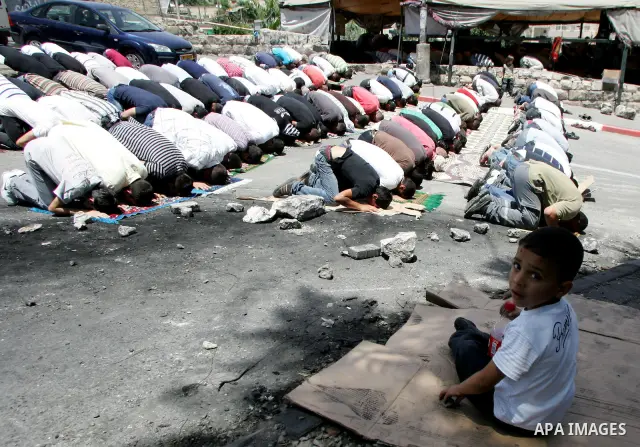 Palestinian Muslim worshippers attend Friday prayers near a protest tent in the mostly Arab neighbourhood of Silwan in east Jerusalem on June 10, 2011. Photo by Mahfouz Abu Turk