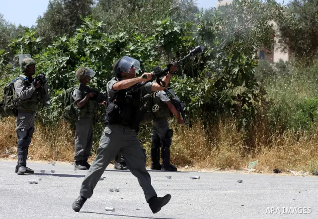 Israeli soldier fires tear gas canister toward Palestinian demonstrators during clashes following a protest against the expropriation of Palestinian land, in the village of Nabi Saleh, in the Israeli-occupied West Bank,...