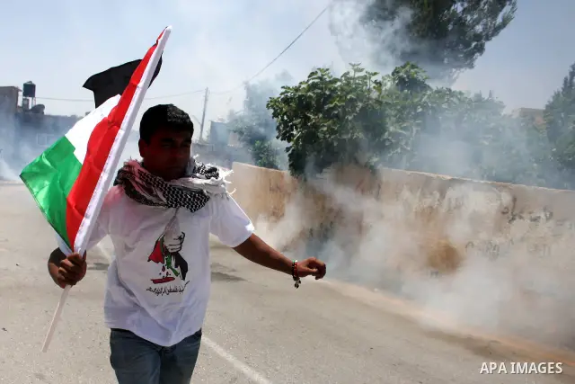Demonstrators run for cover from tear gas canisters fired by Israeli forces during clashes following a protest against the expropriation of Palestinian land, in the village of Nabi Saleh, in the Israeli-occupied West Ban...