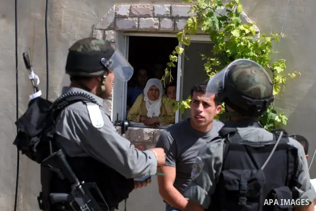Palestinians look at Israeli forces during clashes following a protest against the expropriation of Palestinian land, in the village of Nabi Saleh, in the Israeli-occupied West Bank, on June 10, 2011. Photo by Issam Rima...