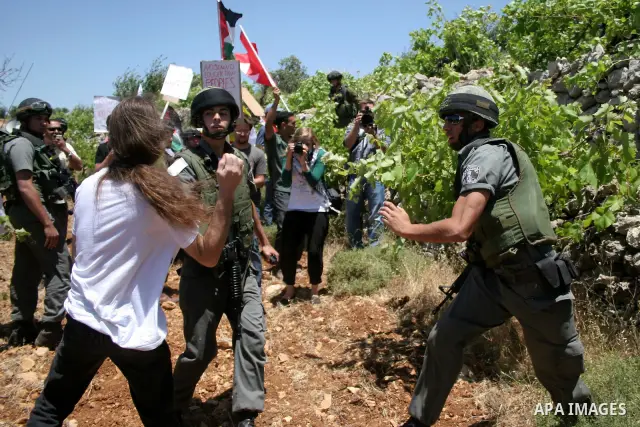 Israeli soldiers stand guard during a demonstration by Palestinian, Israeli and foreign activists against the destroy of farm lands used in the construction of Jewish settlements near the existing Israeli settlement of K...