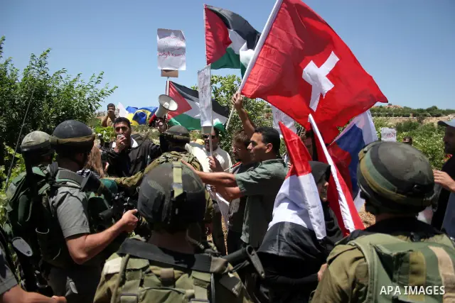 Israeli soldiers stand guard during a demonstration by Palestinian, Israeli and foreign activists against the destroy of farm lands used in the construction of Jewish settlements near the existing Israeli settlement of K...