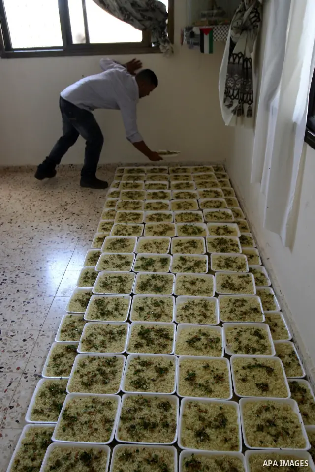 Palestinians prepare dishes of rice and meat for guests attending the wedding celebration of Alaa Sabti in the West Bank village of Salem, near Nablus , June 11, 2011. Photo by Wagdi Eshtayah