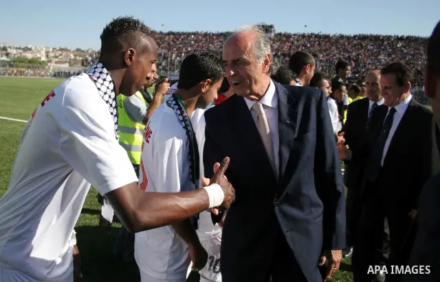 Members of the Italian delegation shake hand with Palestinian players during a friendly football match between the Palestinian and Italian Olympic teams to mark the inauguration of the Dura Stadium near the West Bank cit...