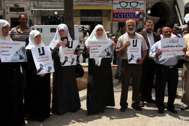 Palestinian Hamas supporters hold banners of relatives who were arrested and imprisoned for political reasons by Palestinian Authority security forces, during a protest in the West Bank city ofof Nablus on June 13, 2011....