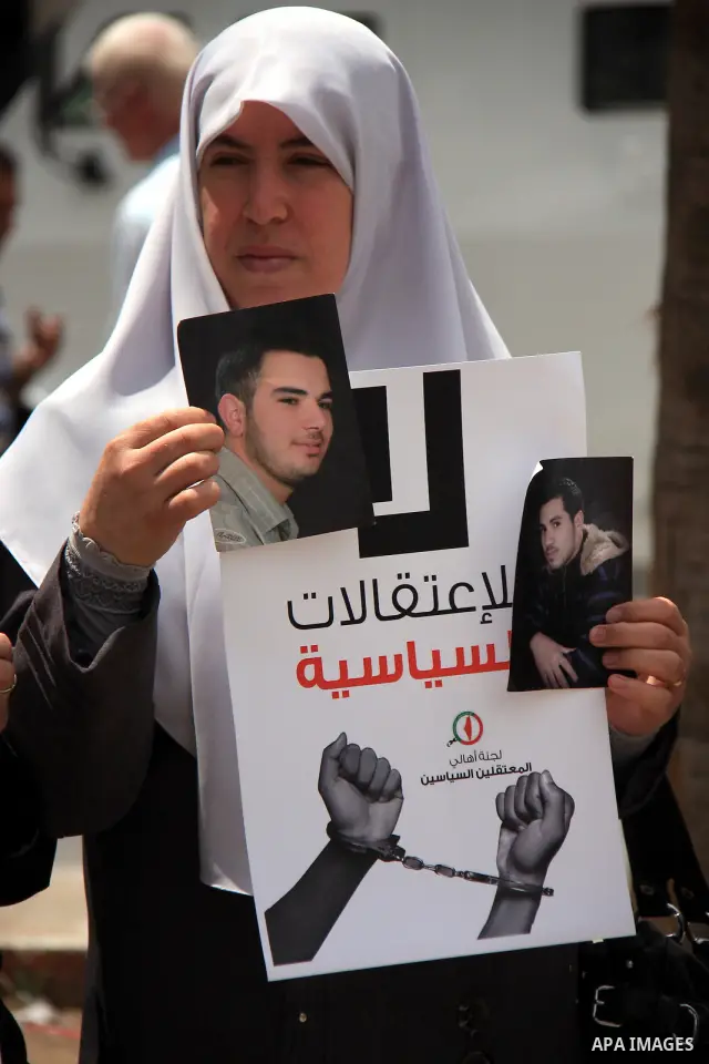 Palestinian Hamas supporters hold banners of relatives who were arrested and imprisoned for political reasons by Palestinian Authority security forces, during a protest in the West Bank city ofof Nablus on June 13, 2011....
