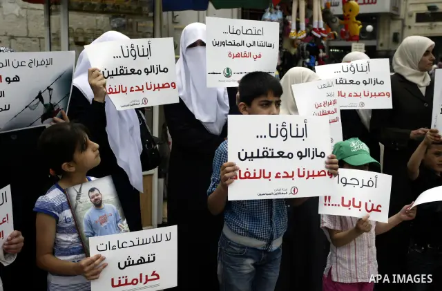 Palestinian Hamas supporters hold banners of relatives who were arrested and imprisoned for political reasons by Palestinian Authority security forces, during a protest in the West Bank city ofof Nablus on June 13, 2011....