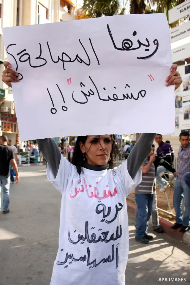 A Palestinian woman holds a banner calling for the release of prisoners for political reasons by the Palestinian security forces during a protest in the West Bank city of Ramallah, on June 13,2011. Photo by Issam Rimawi