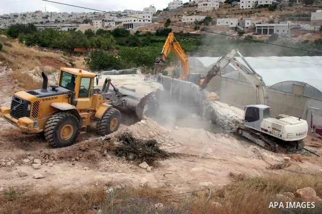 Israeli army machinery destroy a water reservoir used by Palestinian farmers in Hebron, in the Israeli-occupied West Bank, on June 14,2011. Photo by Najeh Hahlamoun.