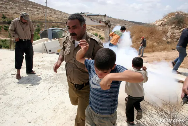 Palestinians argue with Israeli border guards as Israeli army machinery destroy a water reservoir used by Palestinian farmers in Hebron, in the Israeli-occupied West Bank, on June 14,2011. Photo by Najeh Hahlamoun.