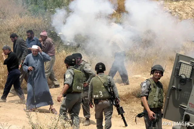 Palestinians argue with Israeli border guards as Israeli army machinery destroy a water reservoir used by Palestinian farmers in Hebron, in the Israeli-occupied West Bank, on June 14,2011. Photo by Najeh Hahlamoun.