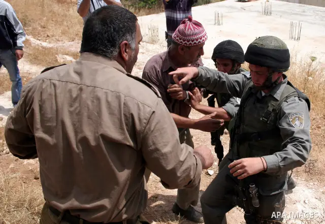 Palestinians argue with Israeli border guards as Israeli army machinery destroy a water reservoir used by Palestinian farmers in Hebron, in the Israeli-occupied West Bank, on June 14,2011. Photo by Najeh Hahlamoun.
