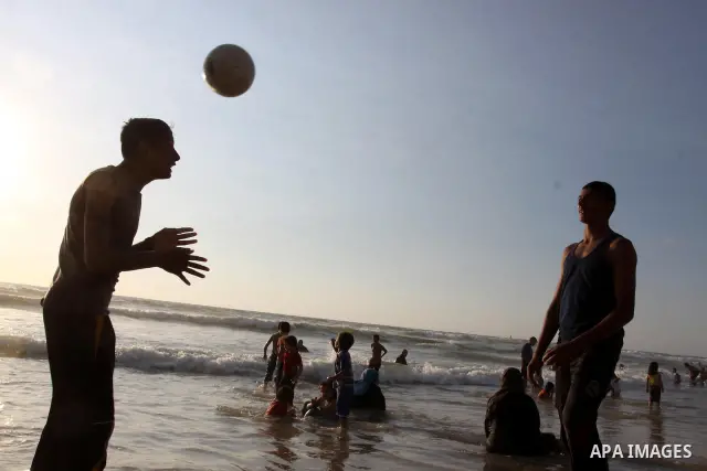 Palestinian youths enjoy swimming and playing football at the beach in Gaza city on June 14, 2011. Photo by Mohammed Asad