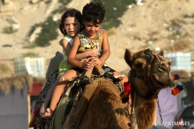 Palestinian children enjoy swimming and riding camels at the beach in Gaza city on June 15, 2011. Photo by Mohammed Asad