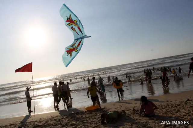 Palestinians enjoy swimming and flying kites at the beach in Gaza city on June 15, 2011. Photo by Mohammed Asad