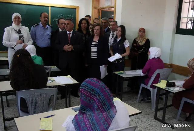 Palestinian Hussein Al-Araj, the representative of the Palestinian President Mahmoud Abbas, visits students as they sit for their final high school exams, known as "Tawjihi", in the West Bank city of Ramallah on June 15,...