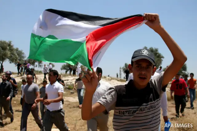 Palestinians from the village of Deir Qadis near Ramallah try to prevent Israeli bulldozers from progressing towards their land during a demonstration against the expansion of nearby settlements on June 15, 2011, in the...