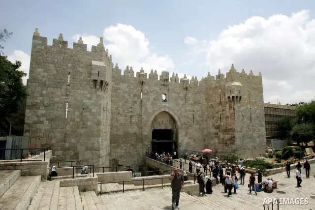 Palestinians walk in front of Damascus gate after its restoration in Jerusalem's old city on Jun 15,2011. Photo by Mahfouz Abu Turk