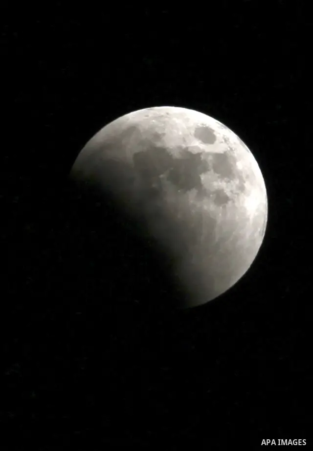 A Portion of the moon crosses into the Earth's shadow seen from the west Bank city of Nablus, on June 15, 2011. Astronomers in parts of Europe, Africa, Central Asia and Australia were hoping for clear skies on June 15 to...
