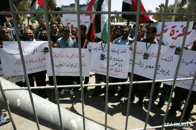 Palestinians hold their national flags and the Egyptian flags and banners during a rally in front of the Rafah border crossing in the southern Gaza Strip on June 16, 2011, demanding it to be open permanently and without...