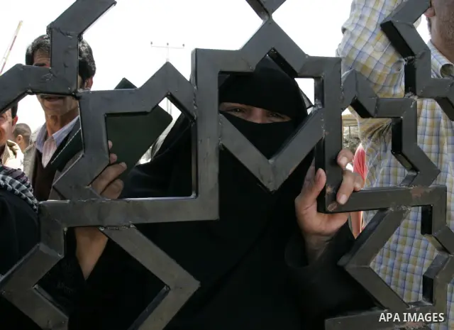 Palestinians stand at the gates of the Rafah border crossing during a rally in the southern Gaza Strip on June 16, 2011, demanding it to be open permanently and without restrictions or conditions on the passengers. Photo...