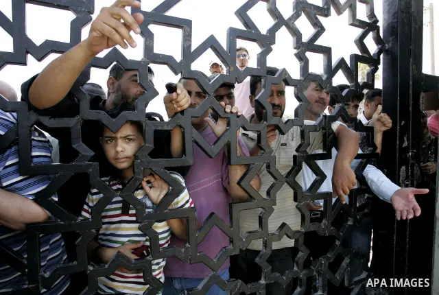 Palestinians stand at the gates of the Rafah border crossing during a rally in the southern Gaza Strip on June 16, 2011, demanding it to be open permanently and without restrictions or conditions on the passengers. Photo...