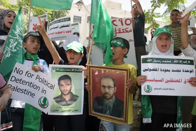 Palestinian Hamas supporters hold up pictures of relatives who were arrested and imprisoned for political reasons by Palestinian Authority security forces, during a protest in the West Bank city of Hebron, on June 16,201...