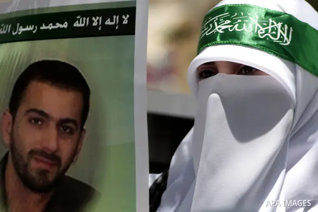Palestinian Hamas supporters hold up pictures of relatives who were arrested and imprisoned for political reasons by Palestinian Authority security forces, during a protest in the West Bank city of Hebron, on June 16,201...