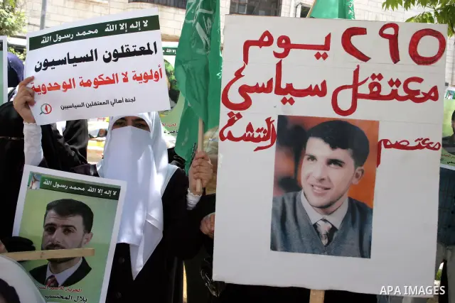 Palestinian Hamas supporters hold up pictures of relatives who were arrested and imprisoned for political reasons by Palestinian Authority security forces, during a protest in the West Bank city of Hebron, on June 16,201...