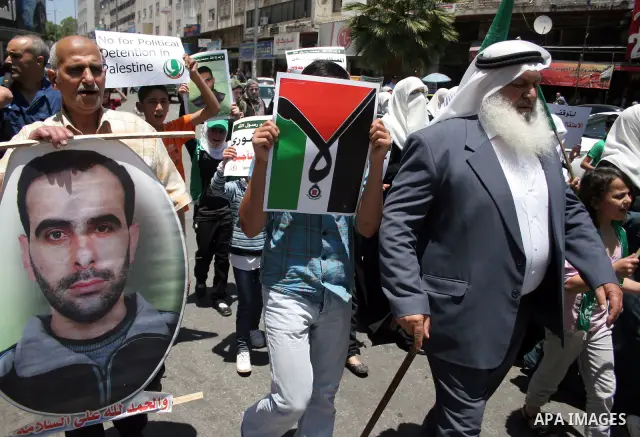 Palestinian Hamas supporters hold up pictures of relatives who were arrested and imprisoned for political reasons by Palestinian Authority security forces, during a protest in the West Bank city of Hebron, on June 16,201...