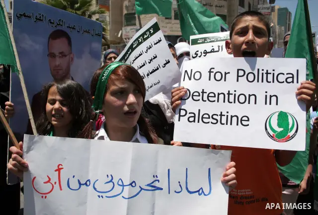 Palestinian Hamas supporters hold up pictures of relatives who were arrested and imprisoned for political reasons by Palestinian Authority security forces, during a protest in the West Bank city of Hebron, on June 16,201...