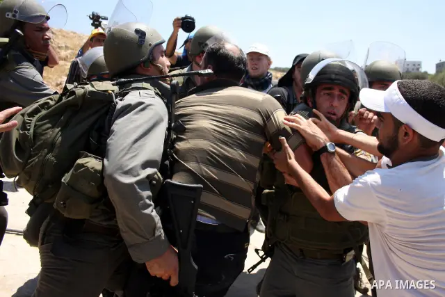 Israeli border guards detain a Palestinian protestor as residents from the village of Deir Qadis near Ramallah hold a demonstration against the expansion of nearby settlements on June 16, 2011, in the Israeli-occupied We...