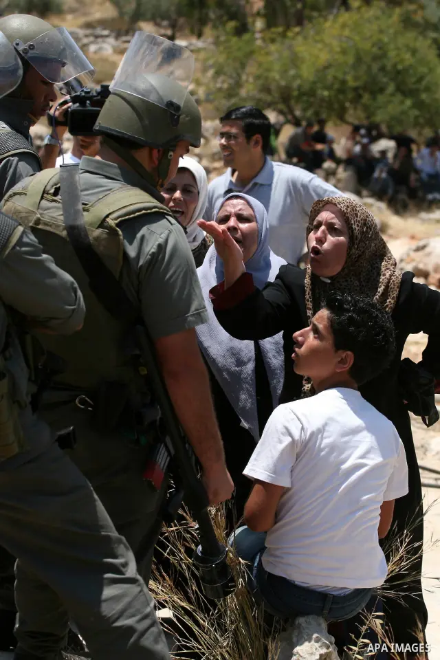Israeli border guards hold back Palestinian protestors as residents from the village of Deir Qadis near Ramallah hold a demonstration against the expansion of nearby settlements on June 16, 2011, in the Israeli-occupied...